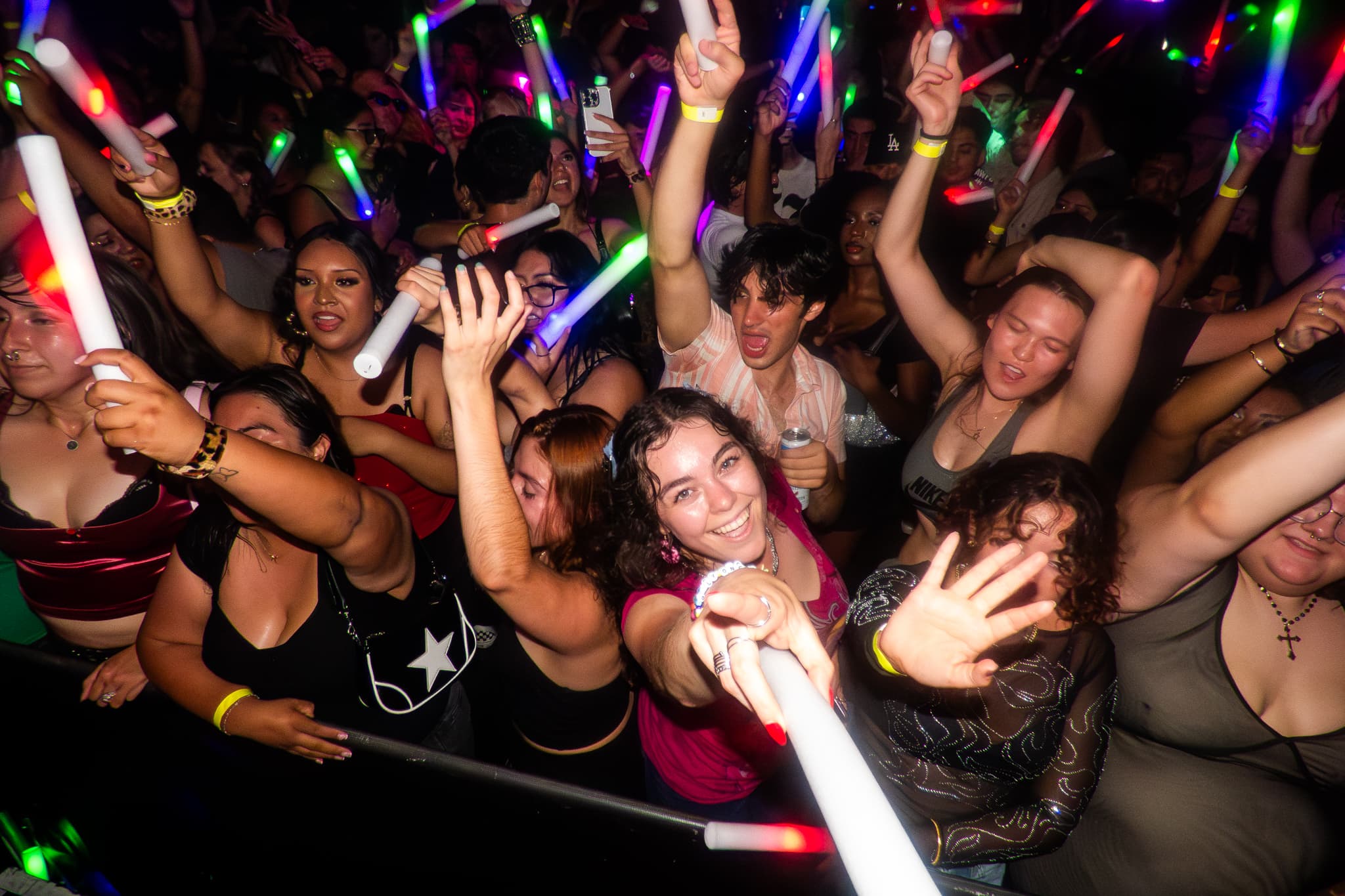 Event photography by Chase Tipton - Photo of a crowd enjoying a live event, hands raised towards the stage with dramatic lighting