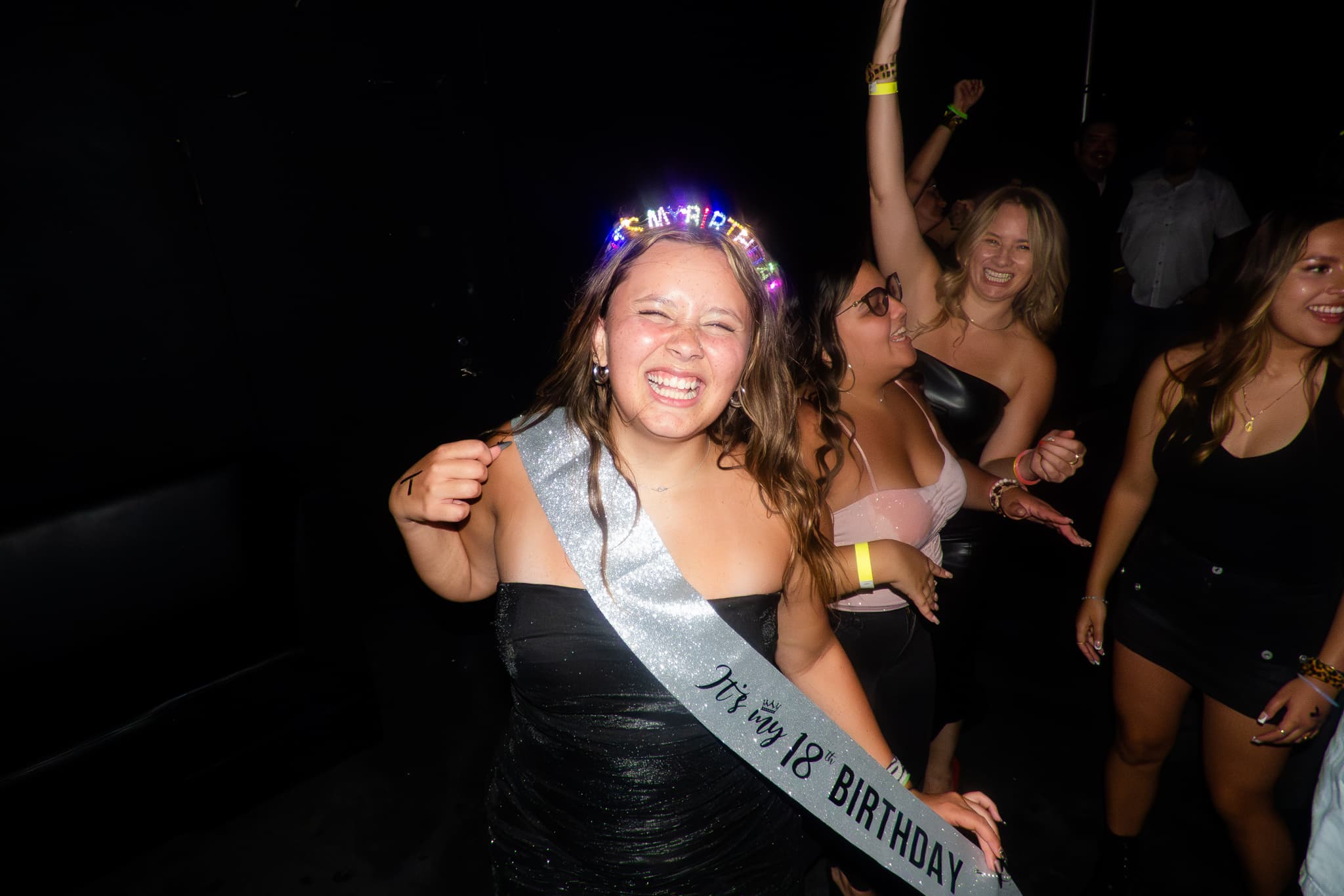 Event photography by Chase Tipton - Photo of a person in a crowd, illuminated by colorful stage lights, enjoying the music at an event, celebratory atmosphere